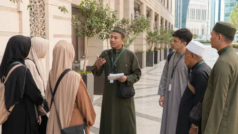 Muthawwif berbahasa Indonesia sedang mengarahkan sekelompok jamaah umroh