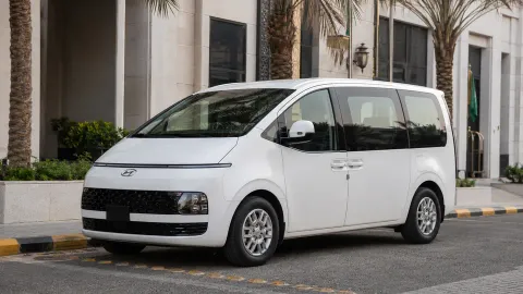 Van penumpang putih terparkir di depan hotel di Arab Saudi